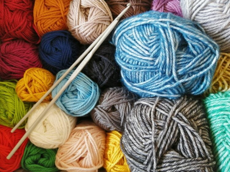 Image of colorful skeins of yarn and two crochet hooks